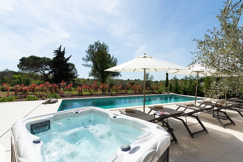 Luxuriöse Villa mit Pool, Sonnenliegen und Whirlpool.