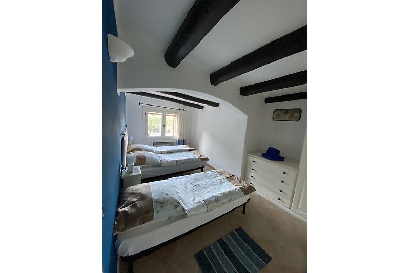 Schlafzimmer mit Doppelbett und zusätzlichem Einzelbett im EG