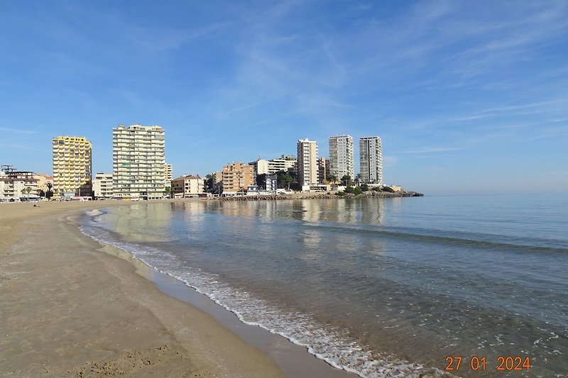 Playa de la Concha. Het appartement is gelegen in de 3de blok van rechts, dus vlakbij de toegang tot het zandstrand.