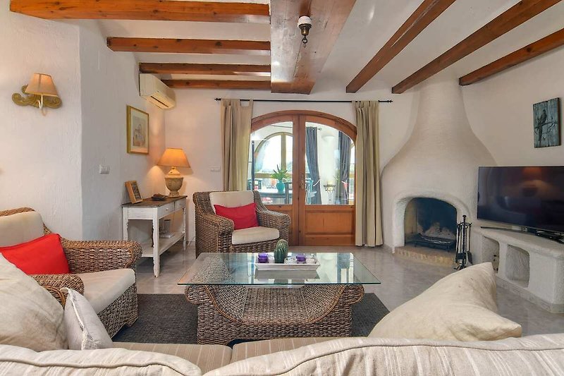 Een comfortabele woonkamer met houten meubels en sfeervolle verlichting.