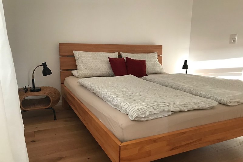 Holzrahmen-Bett mit gemütlichen Kissen und stilvollem Design.