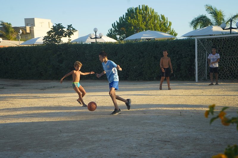 Una partita di calcio estiva su un campo di asfalto in città.