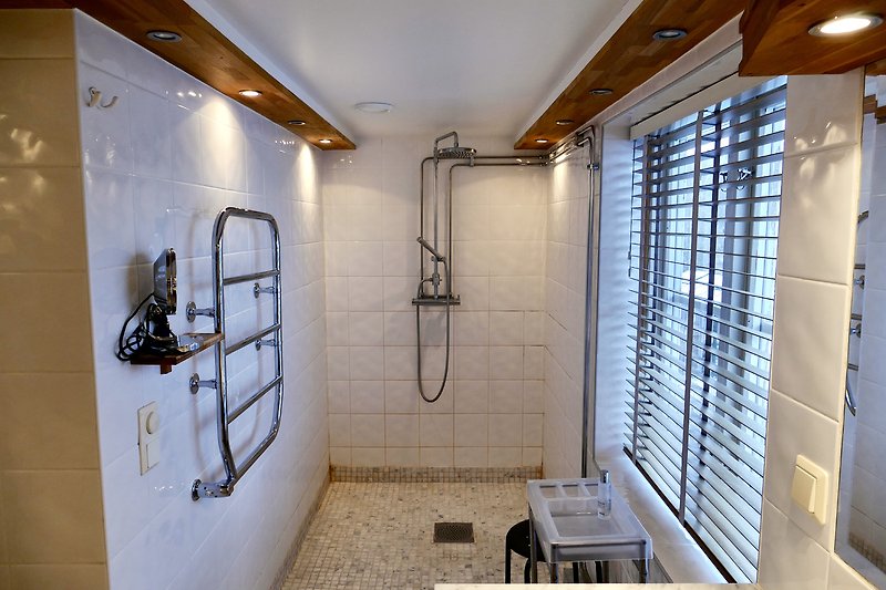 A modern bathroom with sleek fixtures and a stylish shower panel.