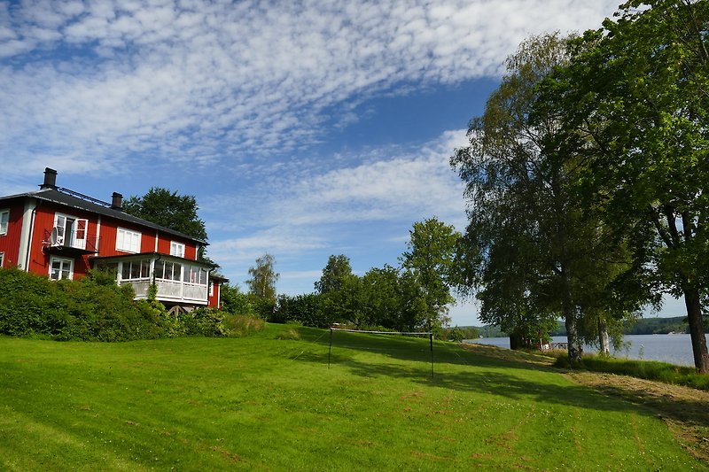 A picturesque property with a beautiful landscape, lush vegetation, and a charming cottage.