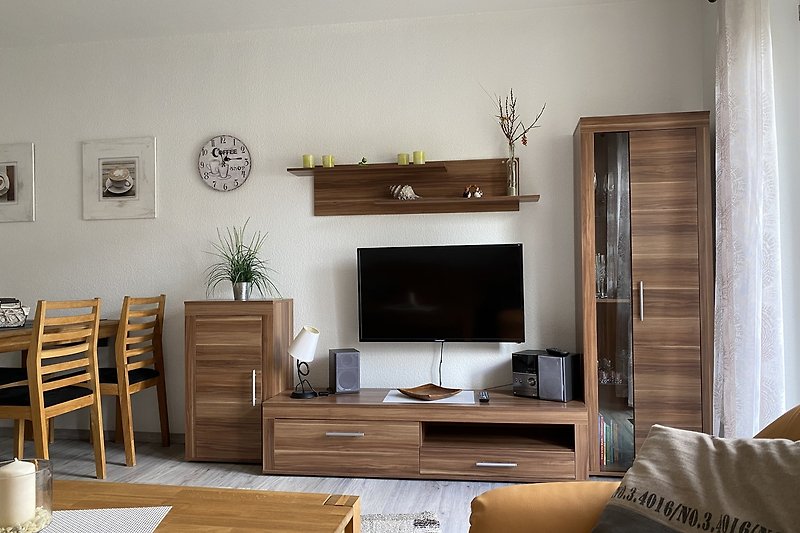 Gemütliches Wohnzimmer mit Holzmöbeln und Pflanzen.
