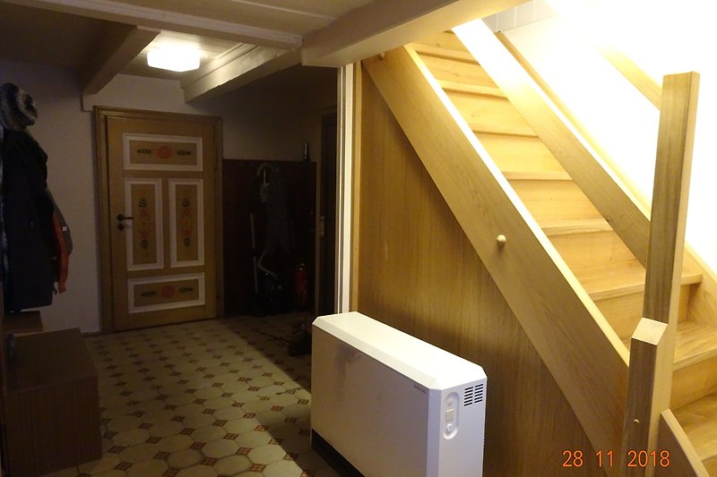 Flur mit bemalten Türen und Holztreppe zum 1.Stock