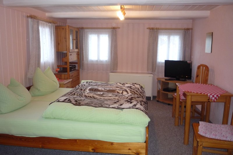 Schlafzimmer  2 mit Holzmöbeln und Vorhängen.