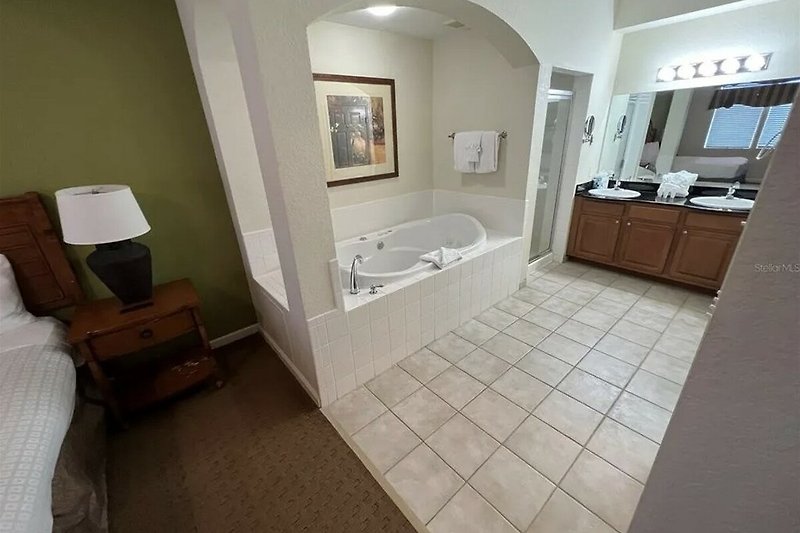 Experience the luxury master bathroom with a modern bathtub, elegant mirror, and sleek fixtures.