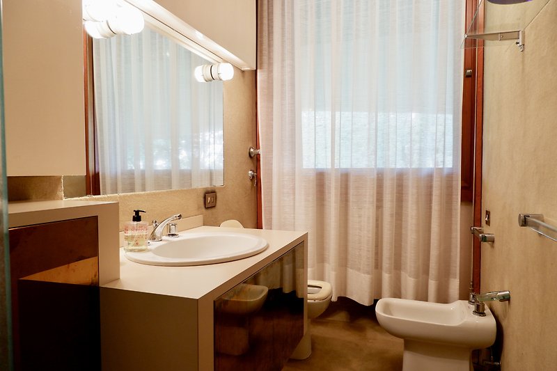 Un bagno viola con un lavandino, una doccia e un pavimento in legno.