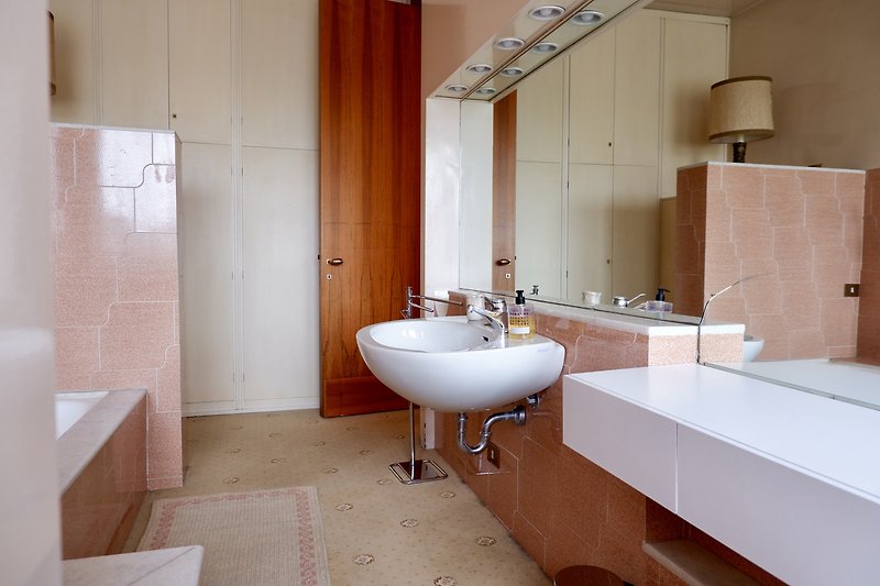 Un bagno elegante con un lavandino in ceramica e uno specchio vasca