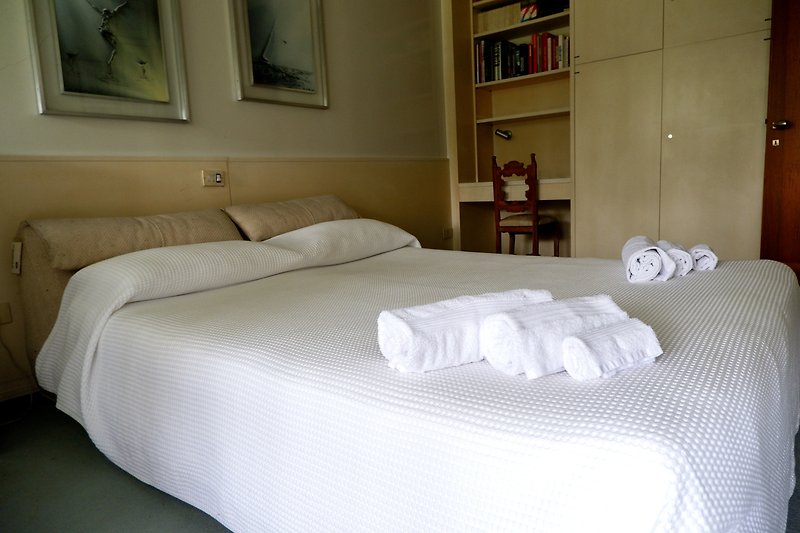 Camera da letto con arredamento in legno, tessuti di alta qualità e un comodo letto.