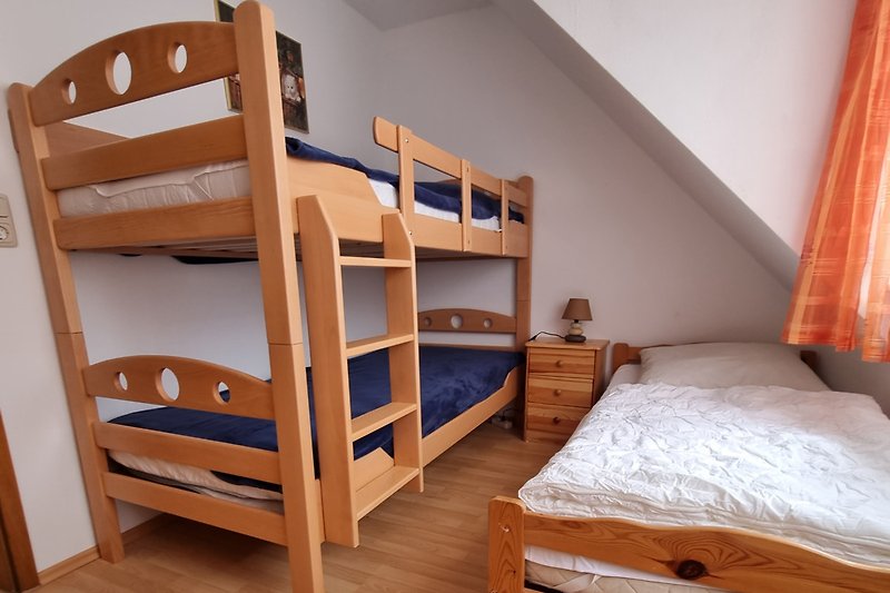 Komfortables Schlafzimmer mit Etagenbett und einem Enzelbett