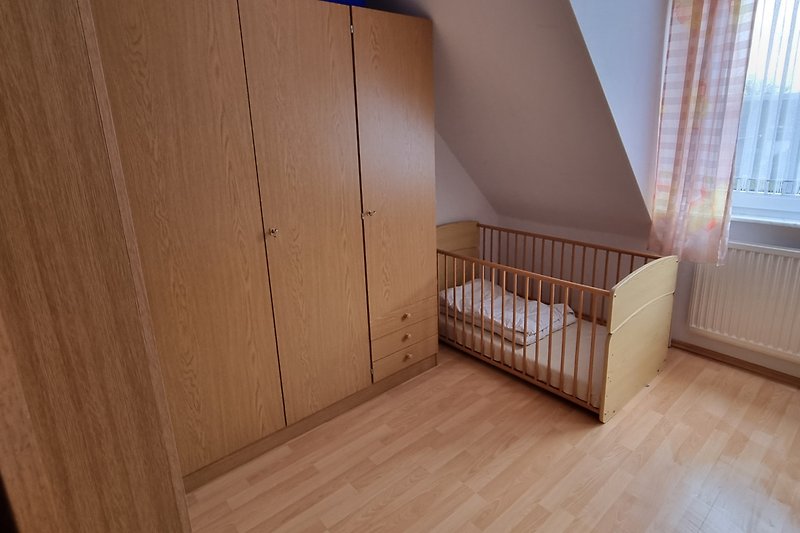 Im Schlafzimmer befindet sich auch ein Babybett, wo man die Holzstäbe raus machen kann