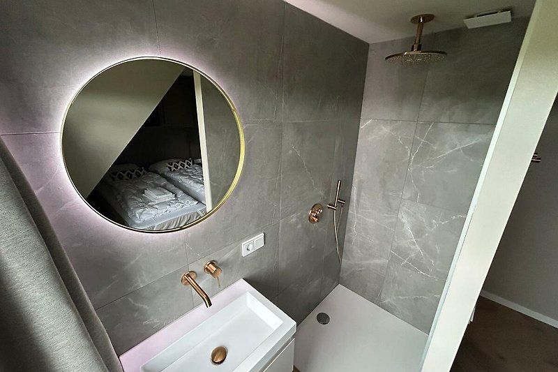 Schönes Badezimmer mit Spiegel, Waschbecken und Armaturen.