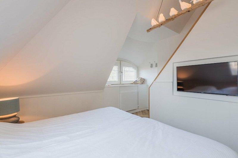 Ein stilvolles Schlafzimmer mit gemütlichem Holzbett und schöner Beleuchtung.