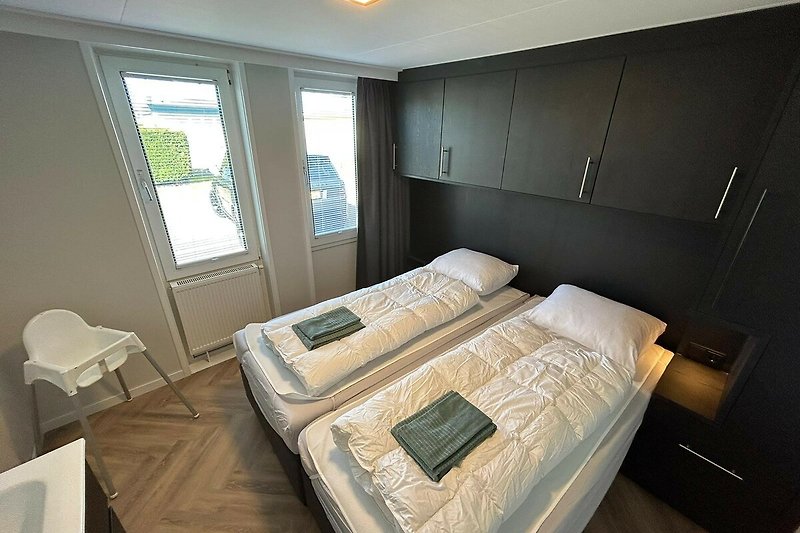 Komfortables Schlafzimmer mit stilvollem Holzbett und hochwertiger Bettwäsche.