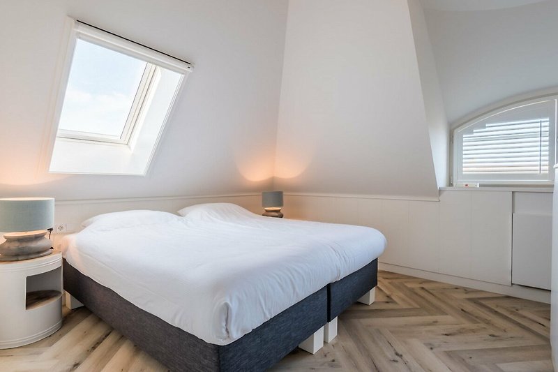 Ein komfortables Schlafzimmer mit stilvoller Einrichtung und gemütlicher Beleuchtung.