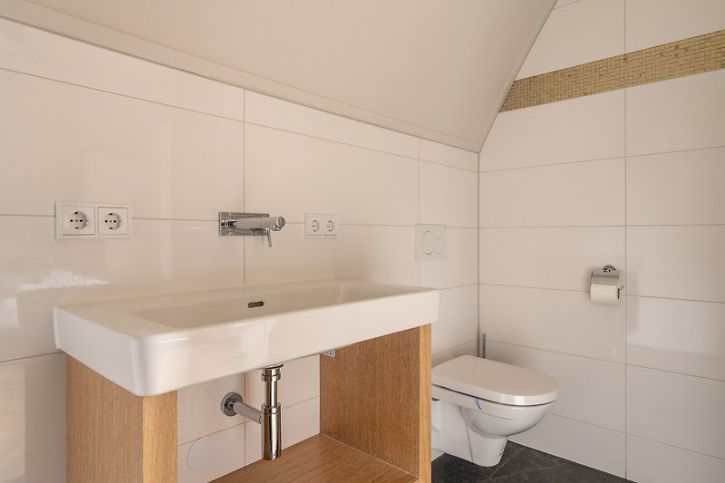Stilvolles Badezimmer mit elegantem Waschbecken und moderner Armatur.