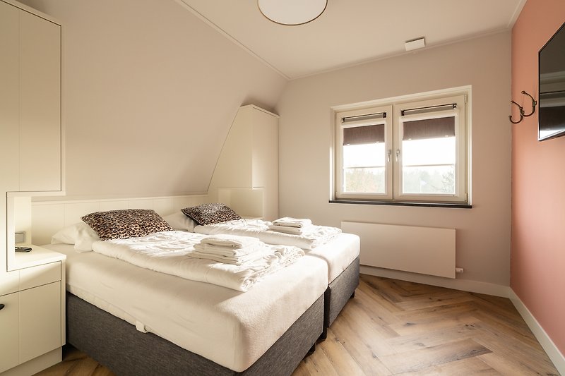 Gemütliches Schlafzimmer mit stilvoller Fensterdekoration und bequemem Bett.