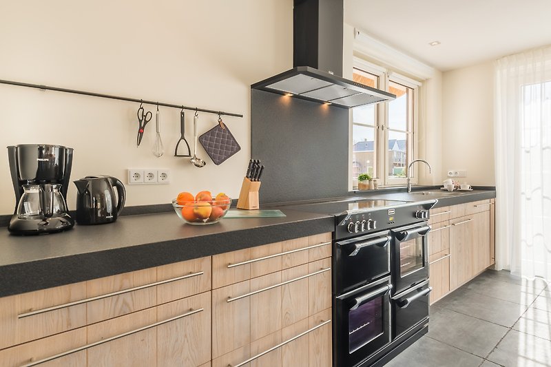 Moderne Küche mit Holzschränken, Granit-Arbeitsplatte und stilvoller Beleuchtung.