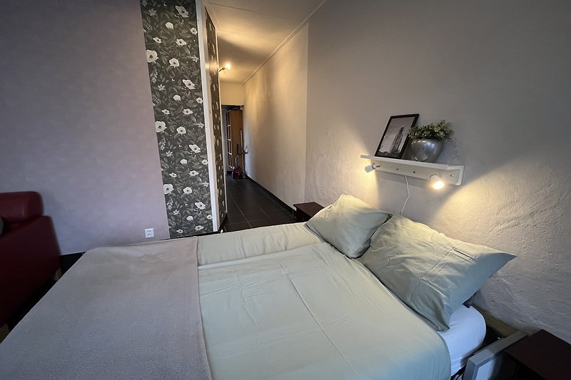 Stilvolles Schlafzimmer mit gemütlichem Bett und Lampenschirm. 140/200