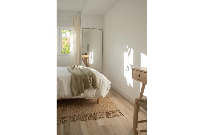 A cozy bedroom with elegant wood flooring and stylish window treatment.