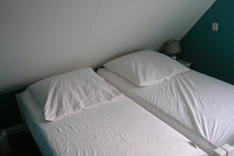 Das gemütliche zweite Schlafzimmer verfügt über zwei einzelne 90 x 200 cm Betten und ein Nachttisch.