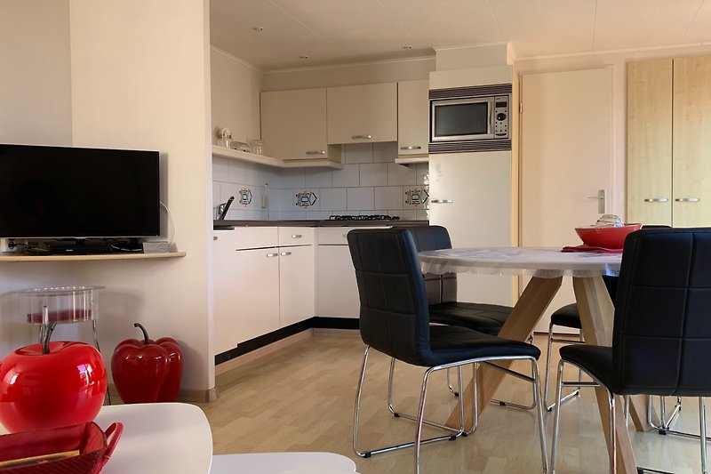 Moderne keuken met comfortabele stoelen en apparaten.