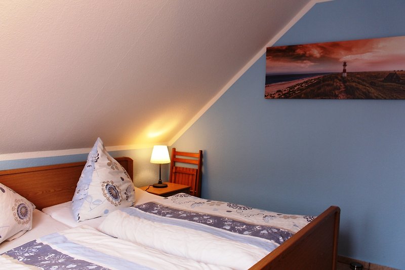 Komfortables Schlafzimmer mit Doppelbett, Holzmöbeln und stilvollem Interieur.