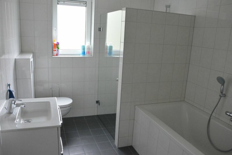 Moderne badkamer met stijlvolle wastafel en glazen douche.