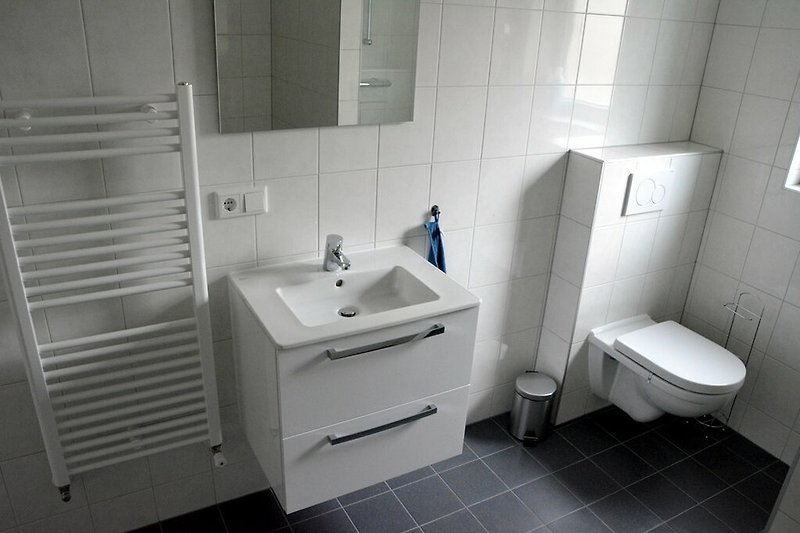 Mooie badkamer met paarse accenten en moderne wastafel.