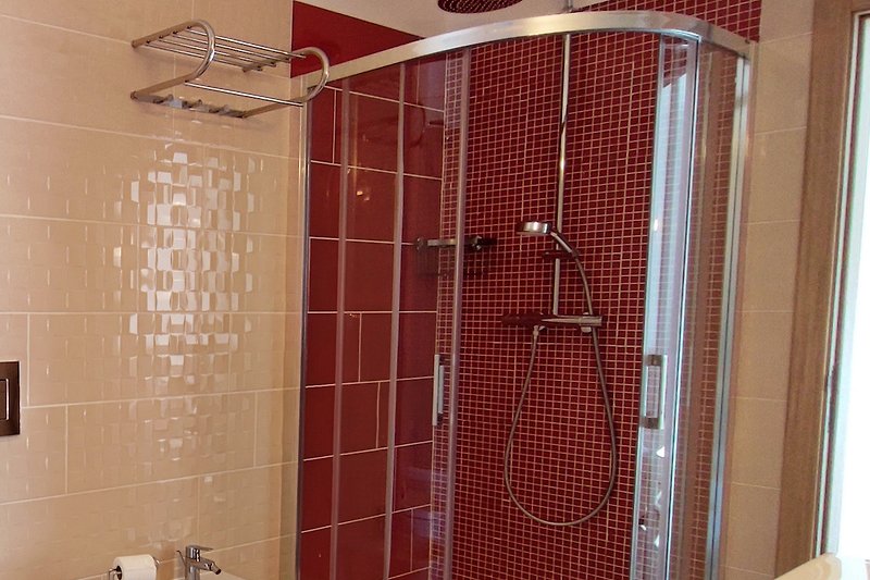 Modern bathroom with sleek fixtures, glass shower door, and stylish tile design.