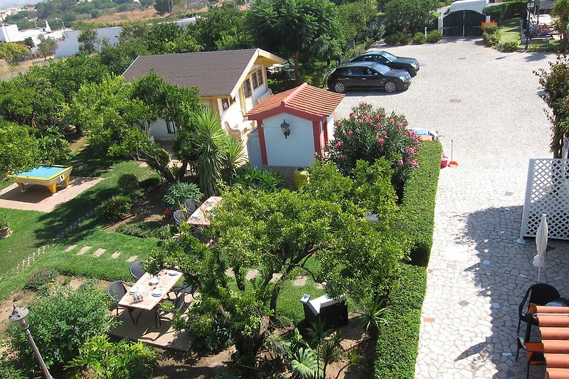A charming property with lush vegetation, a beautiful garden, and a picturesque landscape.