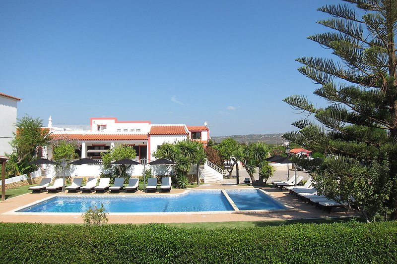 A stunning property with a beautiful landscape and a refreshing swimming pool.