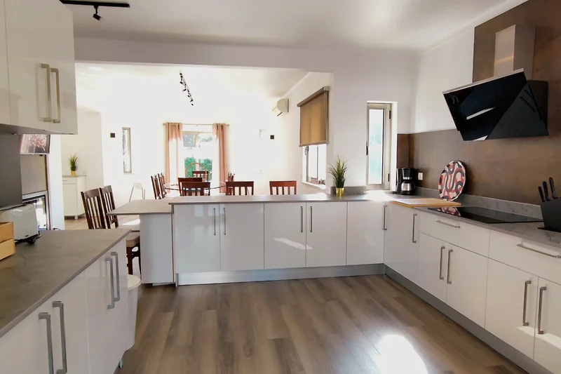 Stilvolle Küche mit Holzschränken und moderner Beleuchtung.