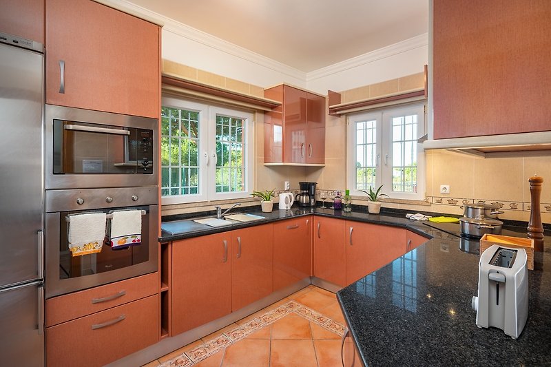Modern kitchen with sleek cabinetry, granite countertop, and stylish appliances.