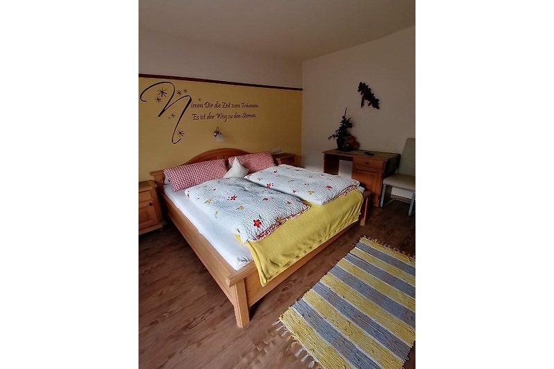 Komfortables Schlafzimmer mit Holzmöbeln und gemütlichem Bett.