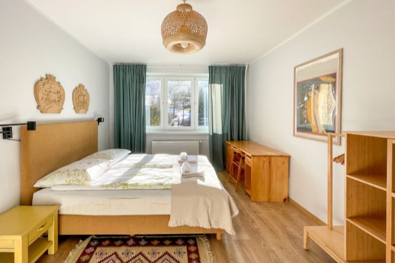 Przytulna sypialnia z drewnianymi meblami i wygodnym łóżkiem.
