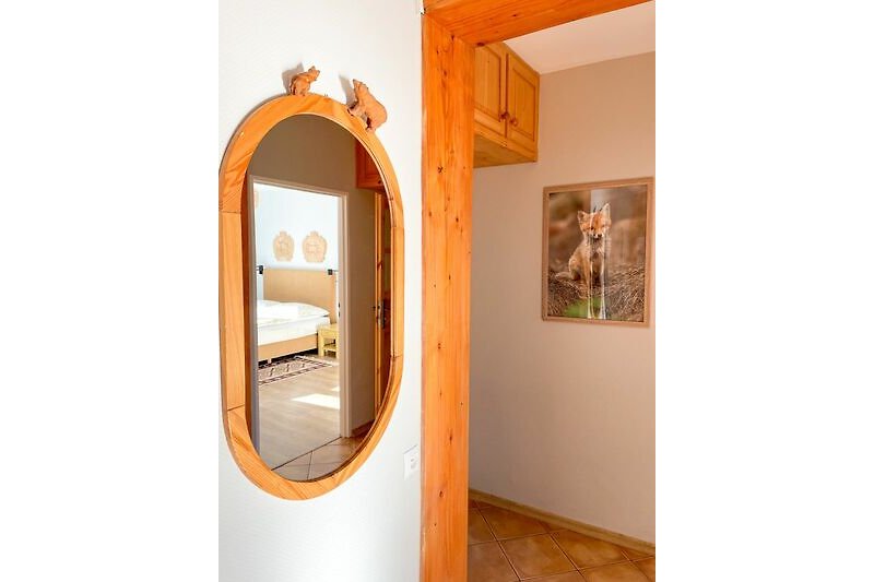 Einladendes Zimmer mit Holzverkleidung, Spiegel und Kunstwerken.