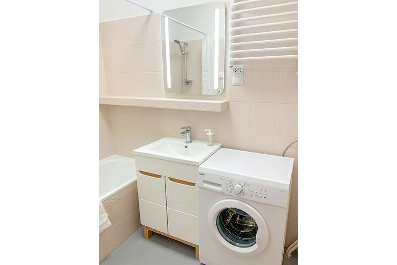 Gemütliches Badezimmer mit lila Akzenten, Waschbecken und Spiegel.