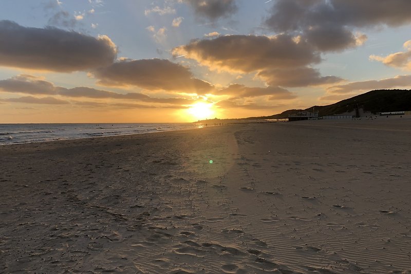 Prachtige zonsondergang aan de kust met kalme golven.