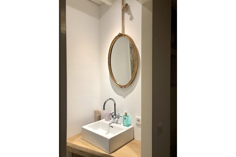 Een moderne badkamer met een mooie spiegel en wastafel.