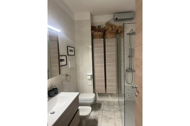 Modernes Badezimmer mit Glas, Metall und Holz.