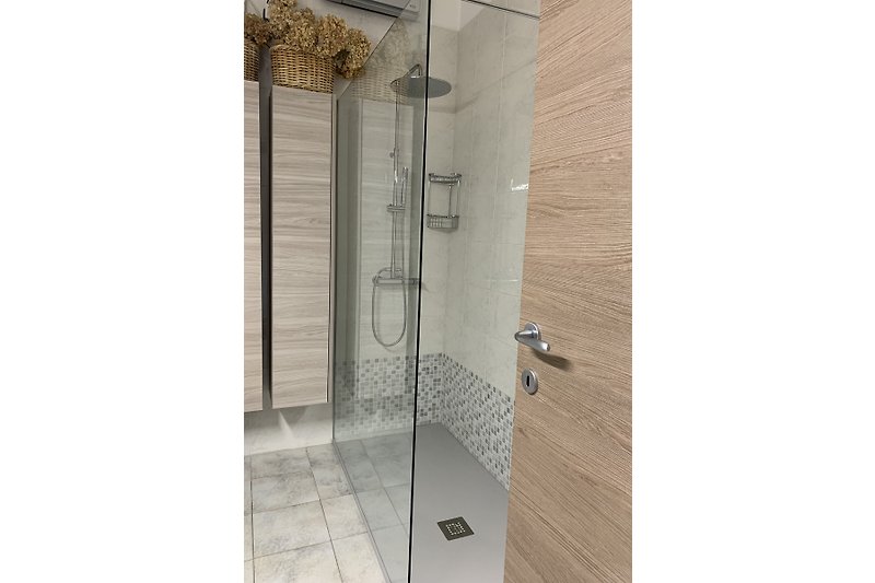 Moderne Dusche mit Glas- und Metallelementen.