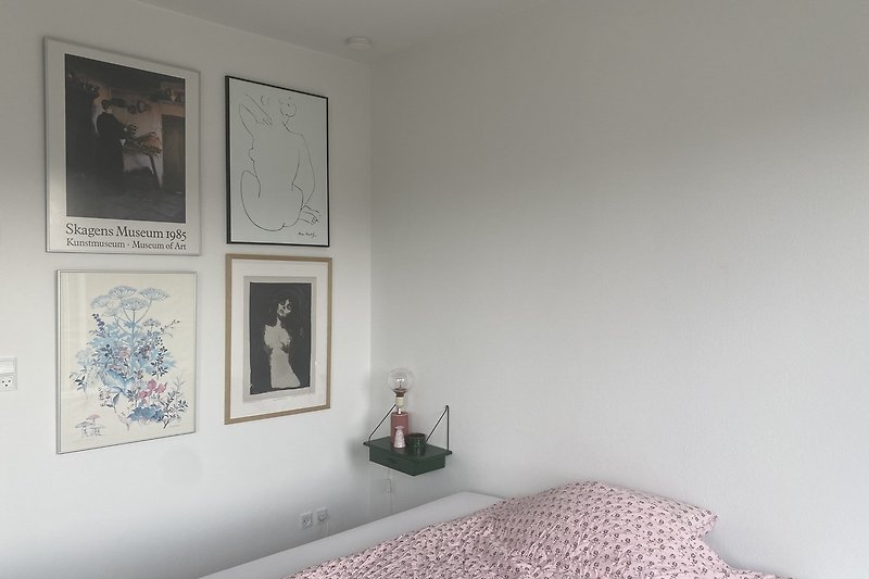 Kunstvolles Schlafzimmer mit monochromer Malerei und Holzbett.
