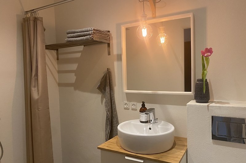 Modernes Badezimmer mit lila Akzenten und stilvoller Beleuchtung.