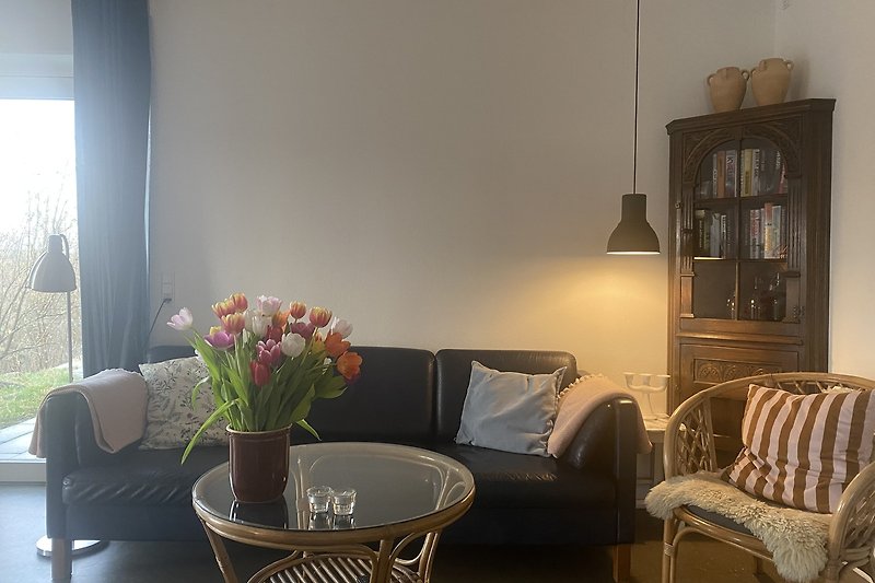 Modernes Wohnzimmer mit bequemer Couch, stilvollem Tisch und schöner Dekoration.