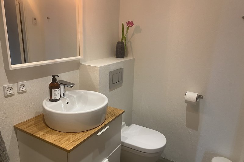Modernes Badezimmer mit lila Akzenten und stilvoller Beleuchtung.