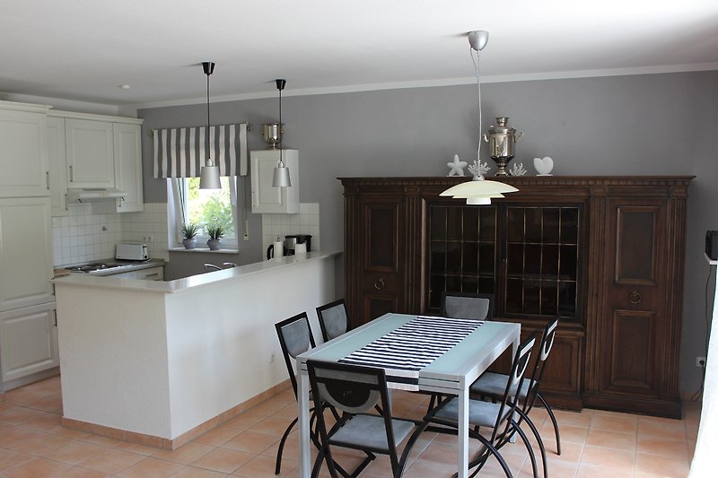 Modern eingerichtete Küche mit grauen Schränken und Holzboden.