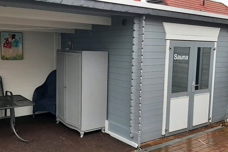 Sauna mit überdachter Sitzecke im Garten